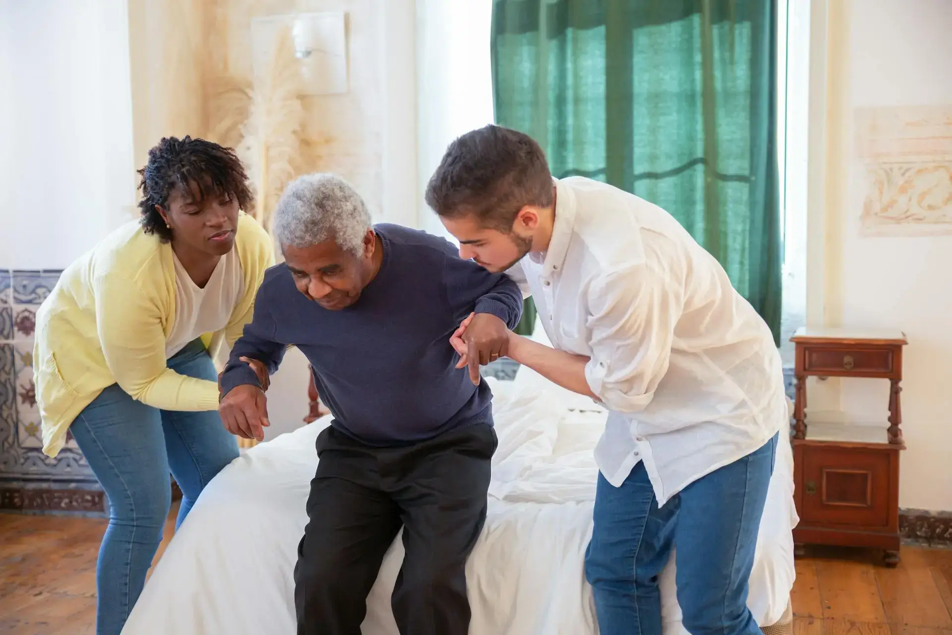 Senior assisted by caregivers
